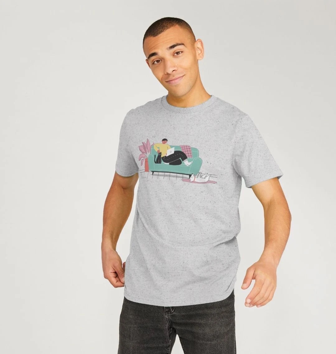 Model wearing a light grey t-shirt with an illustration across the chest. The illustration features a person on a couch with a cat, a dog belly-up on a rug, and a plant.